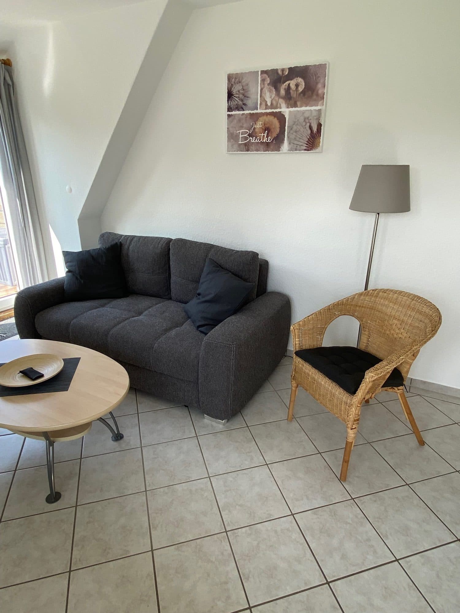 Wohnbereich mit Sofa, Couchtisch und Korbsessel