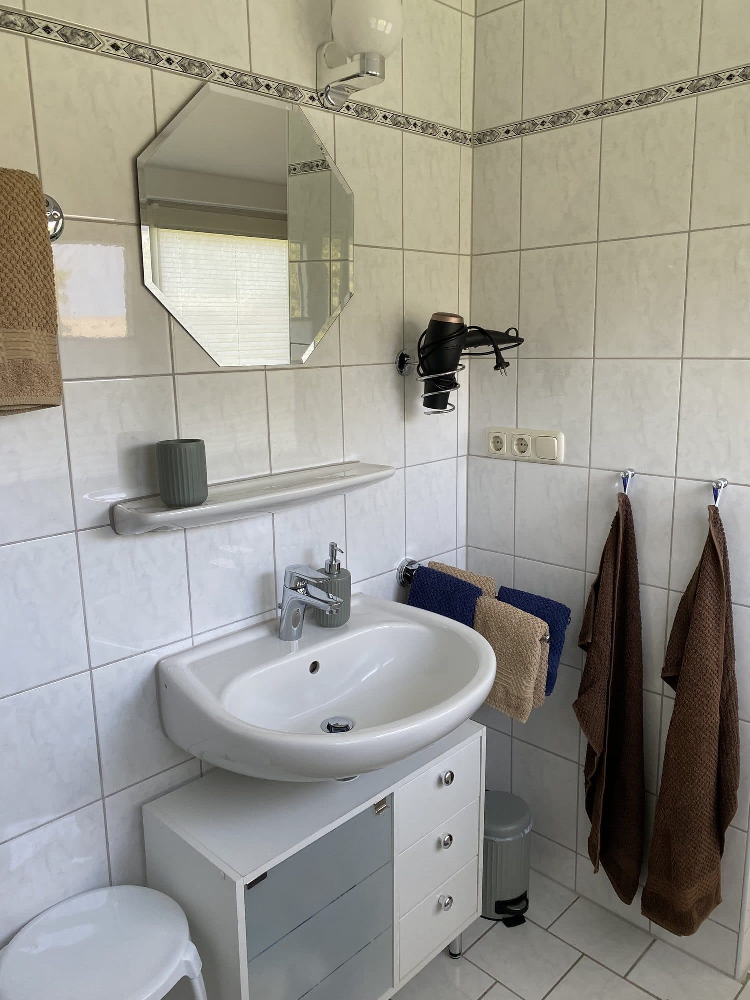 Bad mit Waschbecken, Spiegel und Handtüchern