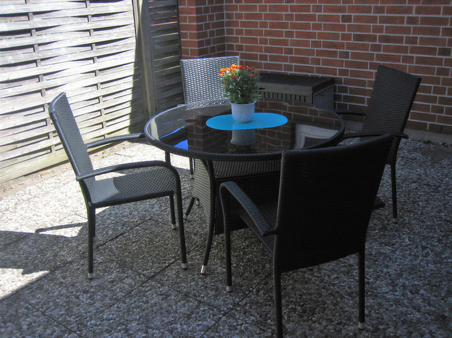 Terrace in the courtyard of the house in Grömitz with a round garden table