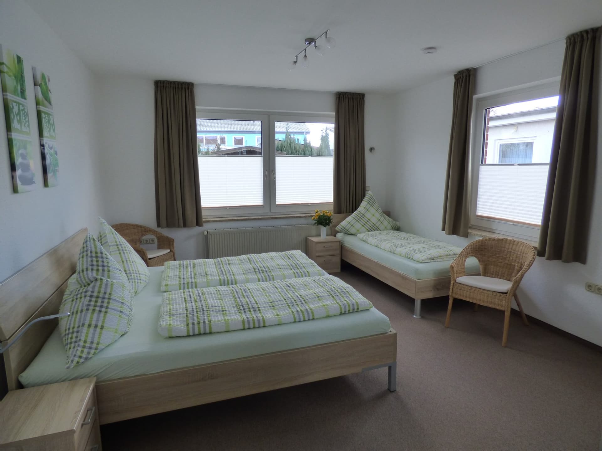 Schlafzimmer mit Doppelbett und zwei Fenstern