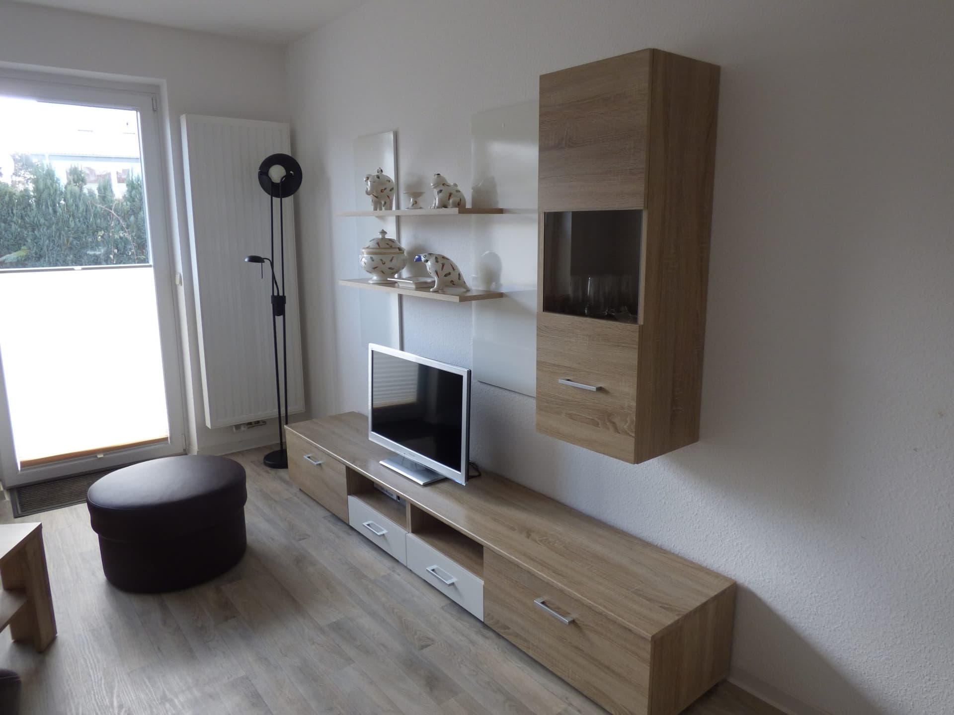 Fernsehwand mit Sitzhocker und Tür zur Terrasse